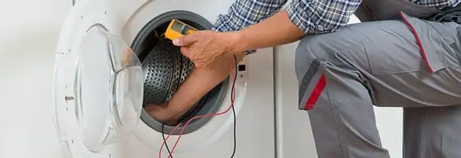 Dryer repair technician inspecting and repairing a clothes dryer in Columbus, GA