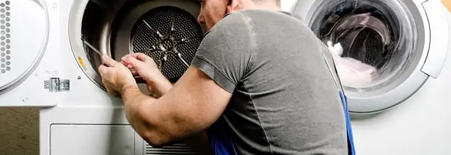 Dryer repair technician fixing a clothes dryer drum in Columbus, GA