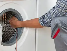 Dryer repair technician diagnosing and servicing a clothes dryer in Columbus, GA