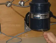 Garbage disposal repair technician tightening the mounting ring under a sink in Columbus, GA