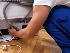 Appliance repair technician fixing refrigerator water line and connections in Columbus, GA