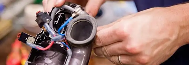 Vacuum repair technician reconnecting wiring and components in Columbus, GA