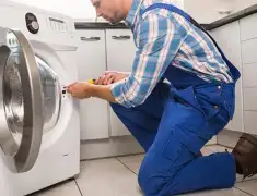Washing machine repair technician servicing a front-load washer in Columbus, GA