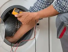 Washing machine repair technician testing a front-load washer with diagnostic tools in Columbus, GA